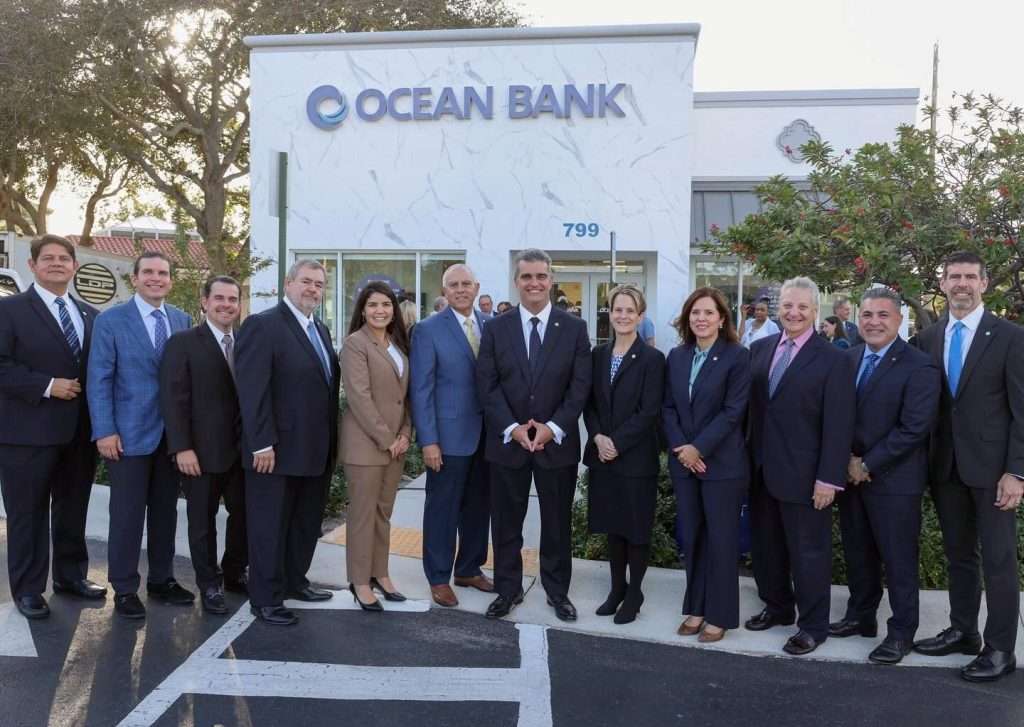 Ocean Bank leadership team posing in front of the new branch in Boca Raton.